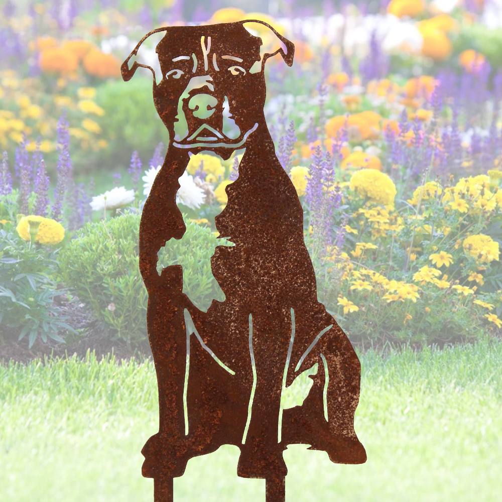 Garden art stakes and a dog statue among plants